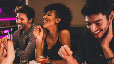 friends laughing over dinner and drinks